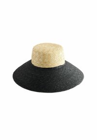 Breda strohhatt med en naturlig solbrun krona och en svart vävd brätte, som har en slät struktur och cirkulär design.