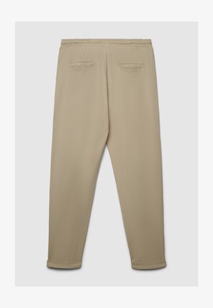 Pantalon de jogging beige avec taille élastique, jambes fuselées et deux poches arrière. Fabriqué en tissu doux et lisse avec une texture subtile.