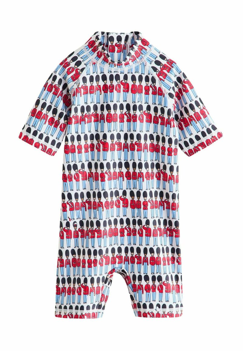 Maillot de bain à manches courtes avec un motif coloré de gardes en manteaux rouges et chapeaux noirs sur un fond bleu clair.