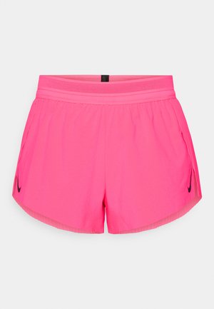 Shorts de sport roses avec une ceinture respirante, dotés de poches latérales et d'un petit logo Nike noir sur le côté gauche. Tissu lisse.