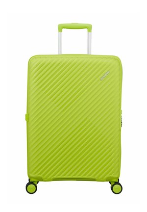 Bright green hard-shell suitcase with diagonal ridges, four black and green spinner wheels, and a retractable handle.