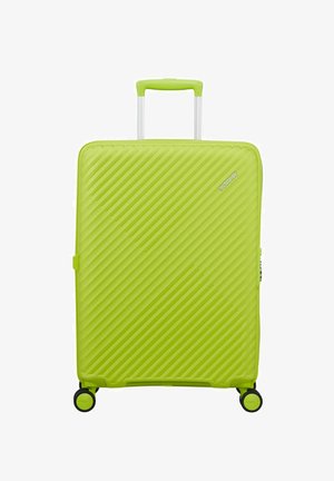 Valise rigide vert vif avec des rainures diagonales, quatre roues pivotantes noires et vertes, et une poignée rétractable.
