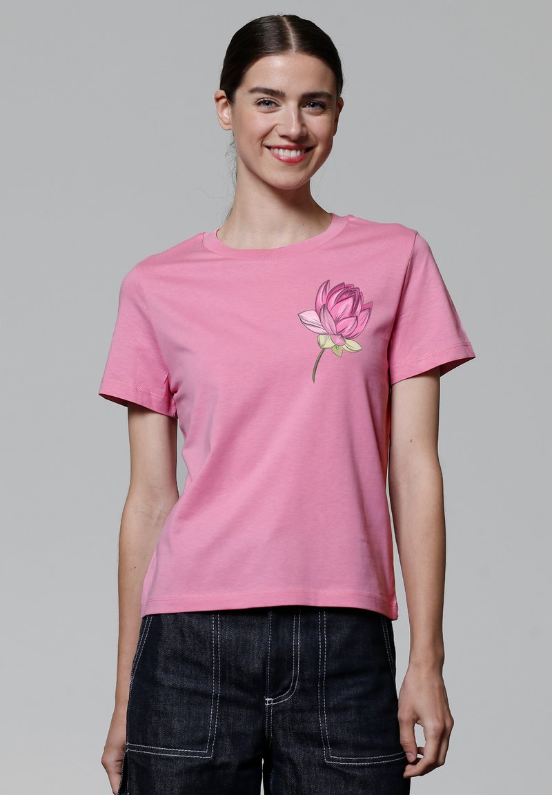 Roze katoenen t-shirt met korte mouwen, ronde halslijn en een lotus bloemen grafiek op de linkerkant van de borst. Zachte textuur, casual pasvorm.