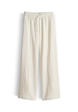 Weite, cremefarbene Hosen mit elastischem Bund und Kordelzug, flach auf weißem Hintergrund liegend dargestellt.