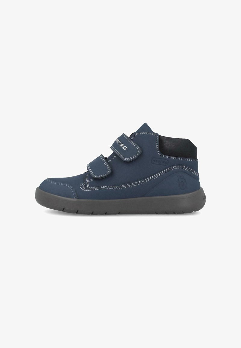Botas de tobillo para niños en azul marino con tiras de Velcro, costuras blancas en contraste, parte superior de tejido suave y suela de goma flexible.