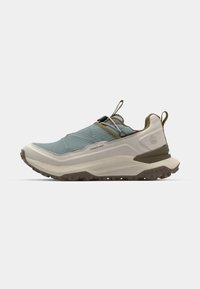 Lightweight trail shoe in light blue and beige. Features a textured upper, elastic laces, and a rugged rubber sole with traction grooves.