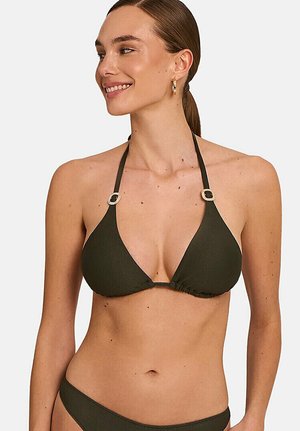 Femme souriante aux cheveux bruns attachés en queue de cheval, portant un bikini côtelé vert foncé avec des bretelles halter et des détails de boucle dorée.