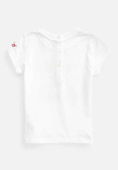Λευκό βαμβακερό πόλο μπλουζάκι με πλακέτα στην πλάτη και τρία κουμπιά. Κοντά μανίκια και κόκκινη λεπτομέρεια λογότυπου στον αριστερό ώμο.