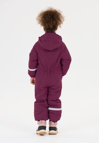 Lilla isoleret snedragt med hætte, elastisk talje og refleksstribe på ærmerne. Designet til varme og bevægelighed, med stumpede ben.