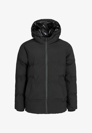 Czarna kurtka puchowa z kapturem, zapinana na zamek z przodu, zestawiona z białym swetrem z wysokim kołnierzem i czarnymi luźnymi dżinsami.