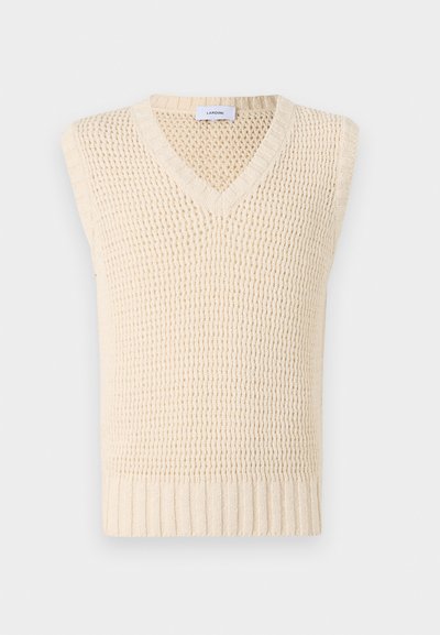 Krēmskrāsas adīts veste ar V veida kakla izgriezumu un bez piedurknēm. Tā iezīmējas ar teksturētu rakstu un ribotu apakšmalu, nodrošinot strukturētu pabeigtību.