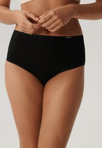 Czarne majtki z wysokim stanem, wykonane z miękkiej bawełny o gładkiej fakturze. Posiadają subtelny metka z logo na pasku.