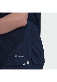 Maglietta sportiva blu navy con un motivo esagonale testurizzato, realizzata in materiale traspirante. Presenta il marchio AEROREADY sull'orlo.