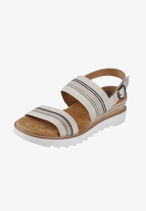 Sandal con cinturini caratterizzata da una tomaia in tela beige con strisce multicolori, una soletta in suede marrone e una suola a zeppa in gomma bianca con bordo testurizzato.