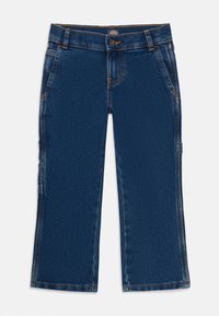 Dunkelblaue Denim-Schneiderhosen mit Knopfverschluss, Seitentaschen und Werkzeugschlaufe am rechten Bein.