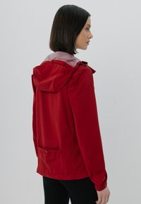 Czerwona kurtka zewnętrzna z kapturem, wykonana z lekkiego materiału, z elastycznymi mankietami i regulowanym miękkim pasem. Gładka tekstura i prosty design.