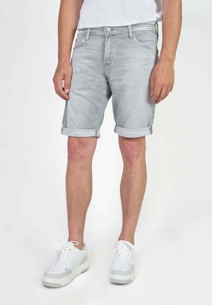 Shorts en denim gris clair avec des poignets retroussés, design à cinq poches et fermeture à bouton, assortis avec des baskets blanches.