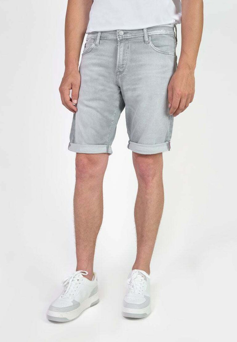 Lichtgrijze denim shorts met opgerolde manchetten, vijf-pocket ontwerp en een knoopsluiting, gecombineerd met witte sneakers.