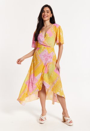 Yellow wrap dress with pink and green paisley patterns, short flutter sleeves, high-low hem, lightweight fabric, featuring a deep v-neck.