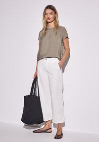 Khaki satin kortærmet top, hvid vide bukser, sort quilted taske og sorte mesh flade sko. Enkel, ren design med en afslappet pasform.