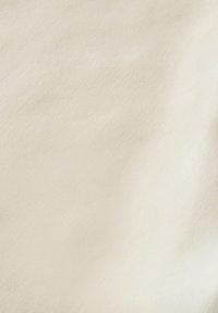 Světlý krémový materiál s hladkou texturou a jemným leskem. Minimální viditelný vzor, vytvářející jednotný vzhled po celé ploše.