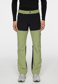 Vihreät ja mustat ulkoiluhousut, joissa on tyylikäs muotoilu ja kestävä kangas. Ominaisuuksiin kuuluu useita taskuja ja istuva vyötärö.