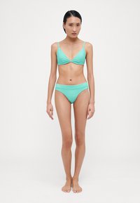 Set de bikini verde menta cu un design texturat, ribbed. Bustieră triunghiulară cu bretele subțiri și chiloți cu talie joasă asortați. Finisaj din material neted.