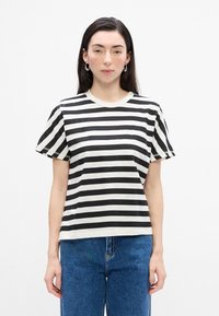 Tricou cu dungi alb-negru, cu mâneci scurte, guler rotund și croială lejeră. Materialul pare neted și ușor.