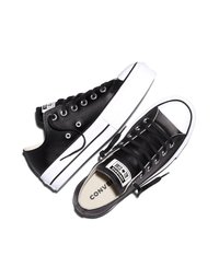 Par av svarta Converse All Star lågskor med vita gummisulor och svarta skosnören, visade från topp- och sidovinklar.