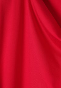 Tissu rouge avec une texture lisse et légèrement brillante. Le matériau tombe doucement, montrant des plis et des ondulations subtiles.