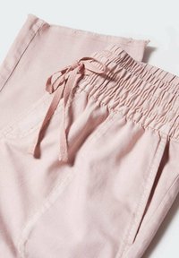 Pantalones rosa claro con cintura elástica, detalle de cordón y bolsillos laterales. La tela tiene una textura suave y un brillo sutil.