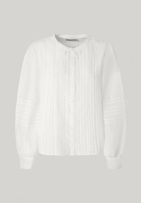 Camicia bianca con bottoni, maniche lunghe a sbuffo, caratterizzata da pieghe verticali, cuciture delicate e scollo rotondo. Tessuto leggero e strutturato.