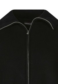 Maglione nero a costine con zip, colletto a punta e dettaglio della cerniera argentata. Presenta un tessuto testurizzato e un'etichetta con il marchio all'altezza del collo.