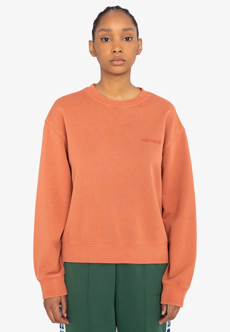 Oranžová mikina s kulatým výstřihem a oversized střihem. Obsahuje žebrované manžety a malé vyšívané logo na hrudi.