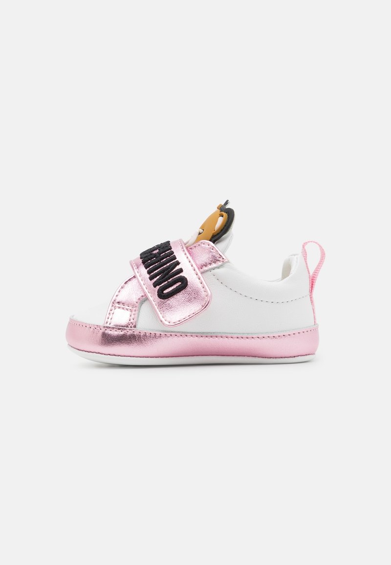 Chaussure bébé blanche et rose avec une bride rose brillante étiquetée "Moschino" et un détail ourson cartoon sur la languette.