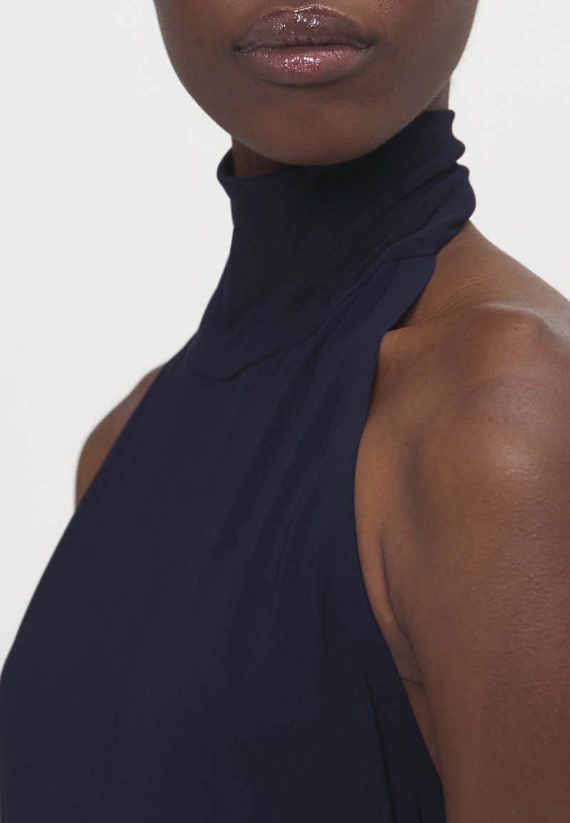 Marineblaues ärmelloses Kleid mit hohem Kragen, das eine glatte Textur und elegantes Drapieren an den Schultern und am Ausschnitt aufweist.