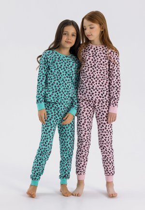 Kaksi lasta käyttää samanlaisia pyjamia, joissa on leopardikuvio. Toisessa on turkoosi tausta mustilla ja vaaleanpunaisilla täplillä, ja toisessa on vaaleanpunainen tausta mustilla täplillä.
