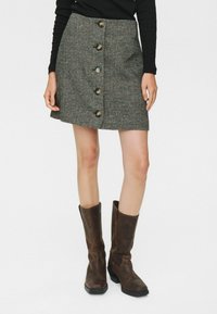 Fustă mini cu model houndstooth, cu o croială dreaptă, având închidere frontală cu butoane și cinci butoane rotunde, confecționată dintr-un material texturat în nuanțe închise.