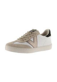 Sneaker bianco e beige con accenti in suede e tessuto, punta rotonda, suola piatta e design con lacci. Dettaglio in pelliccia nera sul tallone.
