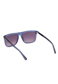 Gafas de sol con una montura azul transparente, lentes oscuros degradados y patillas con acentos negros. Forma rectangular con un acabado brillante.