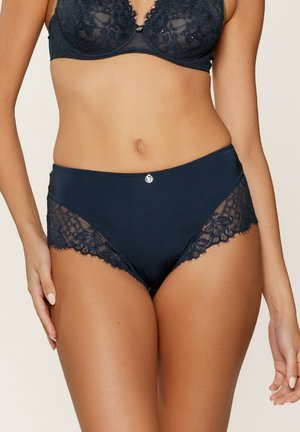 Donkerblauwe hoge taille slip gemaakt van gladde stof met kantenpanelen aan de zijkanten, voorzien van een klein zilveren logo accent op de taille.