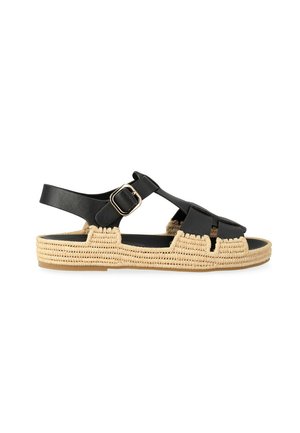 Sandalo in pelle nera con design traforato, fibbia dorata e suola beige intrecciata, mostrato di profilo su sfondo bianco.