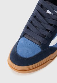 Navy and blue suede sneaker featuring a mesh tongue, tonal laces, and a gum rubber sole with a smooth finish and minimal branding.