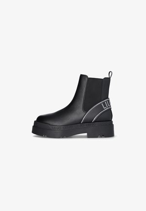 Bottines Chelsea noires avec une tige en cuir lisse, des panneaux latéraux élastiques, une semelle en caoutchouc épaisse et un accent de marque sur le côté.
