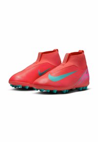Botas de fútbol rojas con un diseño elegante, parte superior texturizada y un prominente swoosh de Nike en turquesa. Presenta un tobillo alto y tacos moldeados.