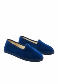 Para niebieskich aksamitem chowanych kapci z czarnymi wykończeniami i podeszwami, pokazanych obok siebie na białym tle.