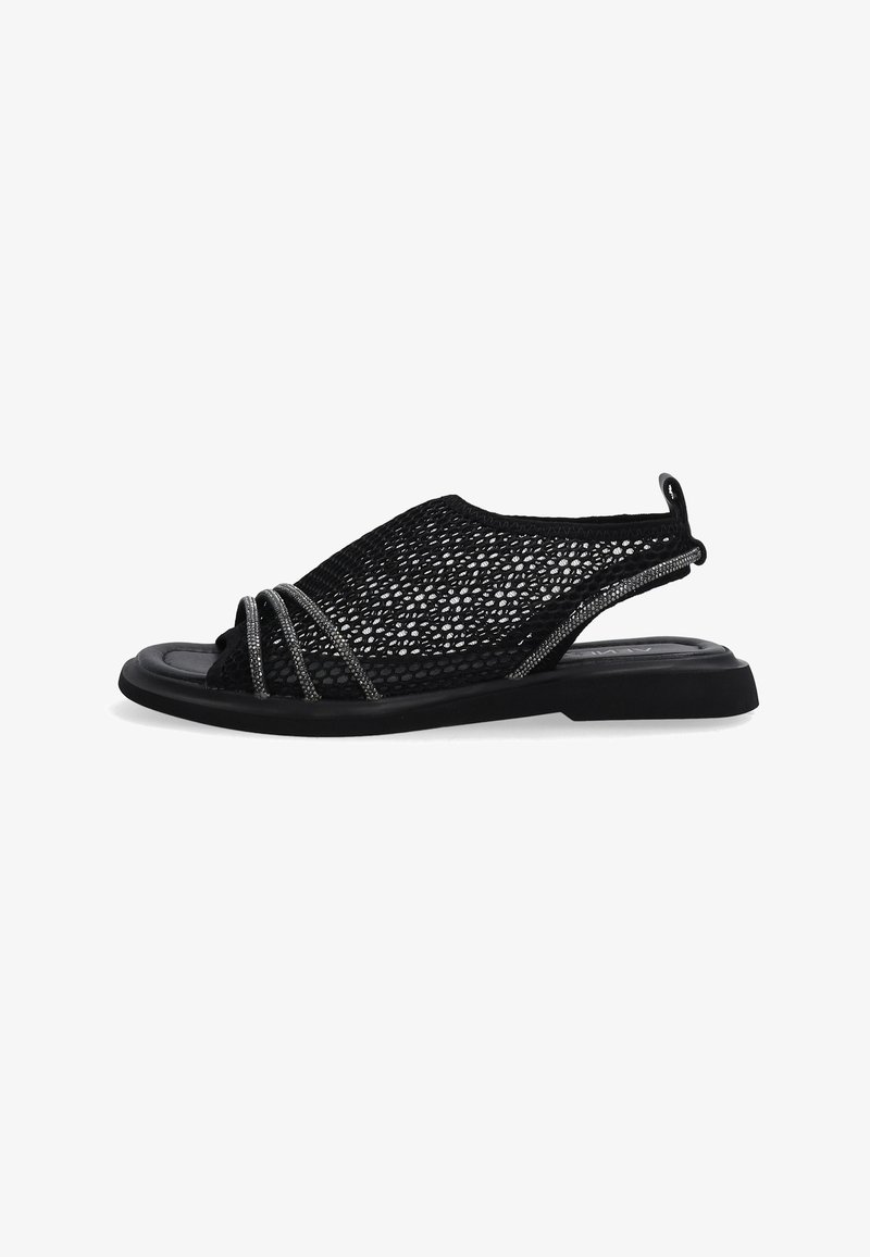 Černé síťované sandály se zavřenou špičkou a otevřenou zadní částí. Obsahují stříbrné copánkové akcenty a plochou černou podrážku pro praktičnost. Lehounký design.