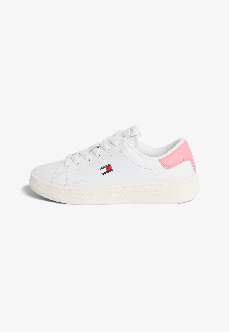 Baskets basses blanches avec empiècement rose au talon, lacets blancs, petit logo drapeau Tommy Hilfiger sur le côté et nom de la marque embossé sur la semelle.