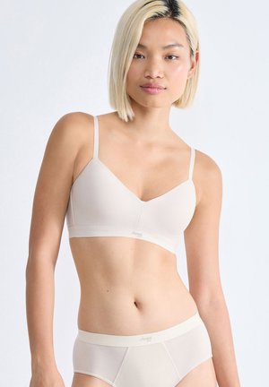 Soutien-gorge sans fil beige avec des bretelles fines et ajustables, texture lisse et décolleté en V, accompagné de culottes sans coutures assorties.