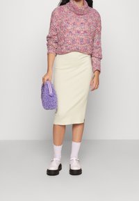 Knitted, cropped sweater in pink and purple hues; fitted cream midi skirt; fluffy lavender handbag; white ribbed socks; beige shoes.